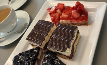 Abschied der BvB-Teilnehmenden im BTZ Braunschweig-Wolfsburg Foto eines Tellers mit Kuchenstücken, daneben eine Tasse Kaffee