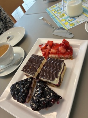Foto eines Tellers mit Kuchenstücken, daneben eine Tasse Kaffee