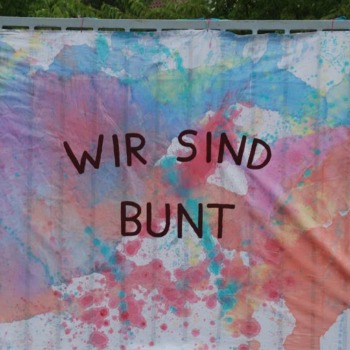 Foto eines bunt bemalten Tuchs mit der Aufschrift "Wir sind bunt": Sommerfest im BTZ Braunschweig-Wolfsburg